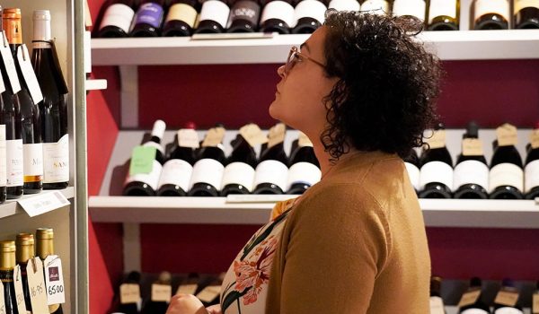 Woman browsing wines at independent wine werchant Stainton Wines, Kendal